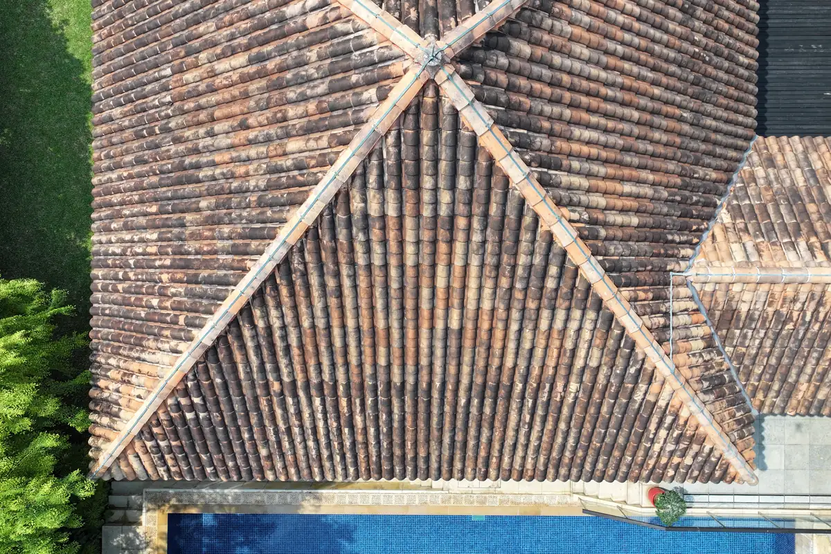 Aerial drone view of a clay tile hip roof during a roof inspection in Singapore